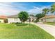 Single-story home with a light-colored facade, landscaping, and a driveway at 120 Grand Oak Cir, Venice, FL 34292