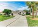 Single-story home with a light-colored facade, landscaping, and a driveway at 120 Grand Oak Cir, Venice, FL 34292