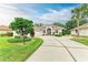 Single-story home with a light-colored facade, landscaping, and a driveway at 120 Grand Oak Cir, Venice, FL 34292