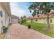 Landscaped side yard with brick-paved pathway at 120 Grand Oak Cir, Venice, FL 34292