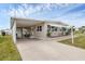 Front view of tan mobile home with carport at 1211 45Th E Ave, Ellenton, FL 34222