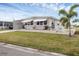 Single-wide manufactured home with carport and landscaped lawn at 1211 45Th E Ave, Ellenton, FL 34222