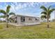 Tan mobile home with palm trees and lawn at 1211 45Th E Ave, Ellenton, FL 34222