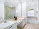 Bathroom features double vanity, soaking tub, and glass block shower at 12317 Baypointe Ter, Cortez, FL 34215