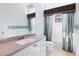 Small bathroom with granite countertop, white cabinets, and teal shower curtain at 12317 Baypointe Ter, Cortez, FL 34215