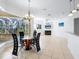 Bright dining area with glass table and four chairs, offering a view of the pool and conservation at 12317 Baypointe Ter, Cortez, FL 34215