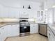White kitchen with stainless steel appliances and ample counter space at 12317 Baypointe Ter, Cortez, FL 34215