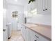 Laundry room with white cabinets, sink, and tile floor at 12317 Baypointe Ter, Cortez, FL 34215