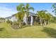 Home features a screened patio, lush landscaping, and expansive grassy yard at 12556 Ryegrass Loop, Parrish, FL 34219