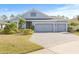 Gray house with two-car garage, landscaping, and paved driveway at 12556 Ryegrass Loop, Parrish, FL 34219