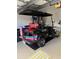 Black golf cart with red seats, rear view in garage at 13146 Borrego St, Venice, FL 34293