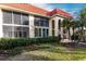 Exterior of condo building, red tile roof, lush landscaping, and screened balconies at 145 Avenida Messina # 3, Sarasota, FL 34242