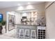 Kitchen with stainless steel appliances, breakfast bar with four stools, and wine rack at 145 Avenida Messina # 3, Sarasota, FL 34242