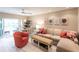 Living room with L-shaped sofa, coral armchair, and dining table near sliding glass doors at 145 Avenida Messina # 3, Sarasota, FL 34242