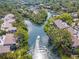 Aerial view of waterfront community with boat and lush landscape at 1701 Pelican Cove Rd # 359, Sarasota, FL 34231