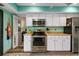 White kitchen cabinets and stainless steel appliances with access to patio at 1701 Pelican Cove Rd # 359, Sarasota, FL 34231