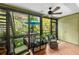 Relaxing sunroom featuring wicker chairs, leafy outdoor views, and tiled floor at 1701 Pelican Cove Rd # 359, Sarasota, FL 34231