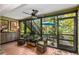 Bright sunroom with patio access, wicker furniture, and leafy views at 1701 Pelican Cove Rd # 359, Sarasota, FL 34231