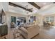 Spacious living room with hardwood floors, sliding doors to pool area, and exposed beams at 18096 Home Run Dr, Venice, FL 34293