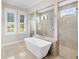 Spa-like bathroom with a freestanding bathtub and walk-in shower at 19458 Beacon Park Pl, Lakewood Ranch, FL 34202