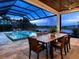 Covered patio with dining table and stunning lake view at 19458 Beacon Park Pl, Lakewood Ranch, FL 34202