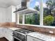 Modern kitchen features stainless steel range and hood, granite counters at 19458 Beacon Park Pl, Lakewood Ranch, FL 34202