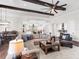 Open concept living room with hardwood floors, a large sectional sofa, and views to the kitchen and dining area at 19458 Beacon Park Pl, Lakewood Ranch, FL 34202