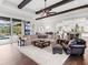 Relaxing living room featuring hardwood floors, comfortable seating, and access to the backyard pool area at 19458 Beacon Park Pl, Lakewood Ranch, FL 34202