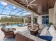 Comfortable patio furniture with a fire pit and lake view at 19458 Beacon Park Pl, Lakewood Ranch, FL 34202