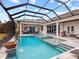 Expansive pool area with covered patio, spa, and lake view at 19458 Beacon Park Pl, Lakewood Ranch, FL 34202