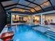 Stunning pool and patio area with covered lanai, outdoor kitchen, and multiple seating areas at 19458 Beacon Park Pl, Lakewood Ranch, FL 34202