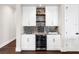 Built-in wet bar with granite countertop, wine cooler, and white cabinetry at 19458 Beacon Park Pl, Lakewood Ranch, FL 34202