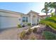 Well-maintained single-story home with a manicured lawn, mature trees and a two car garage at 219 Heritage Isles Way, Bradenton, FL 34212