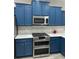 Kitchen with stainless steel appliances, blue cabinets, and a decorative backsplash at 219 Heritage Isles Way, Bradenton, FL 34212