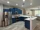 Spacious kitchen showcasing stainless steel appliances, blue cabinets, and an open layout at 219 Heritage Isles Way, Bradenton, FL 34212