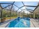 Sparkling screened pool with a waterfall feature and lush backyard views at 219 Heritage Isles Way, Bradenton, FL 34212