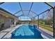 Inviting screened pool with a waterfall feature, lounge area, and views of the backyard at 219 Heritage Isles Way, Bradenton, FL 34212