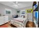 Charming bedroom with terracotta floors, butterfly art, and built-in shelving at 3414 Old Oak Dr, Sarasota, FL 34239