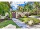 Front yard with walkway, gate, and lush tropical plants at 3414 Old Oak Dr, Sarasota, FL 34239