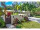 House with red door, wooden gate, and nicely landscaped yard at 3414 Old Oak Dr, Sarasota, FL 34239