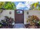Wooden gate entry to the property with landscaping at 3414 Old Oak Dr, Sarasota, FL 34239