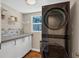 Modern laundry room with white cabinets and LG stacked washer and dryer at 3414 Old Oak Dr, Sarasota, FL 34239