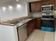 Modern kitchen with dark wood cabinets, stainless steel appliances, and granite counters at 3606 Beneva Rd # 502, Sarasota, FL 34232
