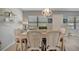Dining room with wicker chairs, glass-top table, and a white chandelier at 435 30Th W Ave # D309, Bradenton, FL 34205