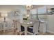 Charming dining area with wicker table and chairs, stylish chandelier, and decorative shelves at 435 30Th W Ave # D309, Bradenton, FL 34205