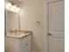 Small bathroom with granite countertop, white cabinets, and mirror at 4584 Hidden River Rd, Sarasota, FL 34240