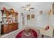 Sitting area with ornate cabinet and red rug at 5015 Jagged Cloud Dr, Wimauma, FL 33598