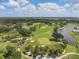 Aerial view of a golf course with lush green fairways and waterways at 5128 Marsh Field Ln # 129, Sarasota, FL 34235