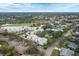 Aerial view of community featuring multiple buildings, lush landscaping, and a pool at 5128 Marsh Field Ln # 129, Sarasota, FL 34235