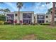 Exterior view of condo building with lush landscaping and grassy lawn at 5128 Marsh Field Ln # 129, Sarasota, FL 34235